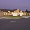 Street of twin homes with lit porches at dusk