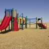 Playground with red slides and a bench